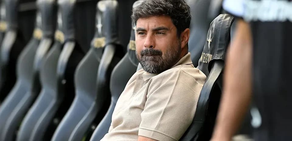 Coach seated on bench during a match