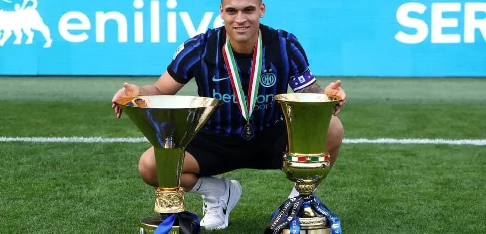 Player celebrating with two trophies on field