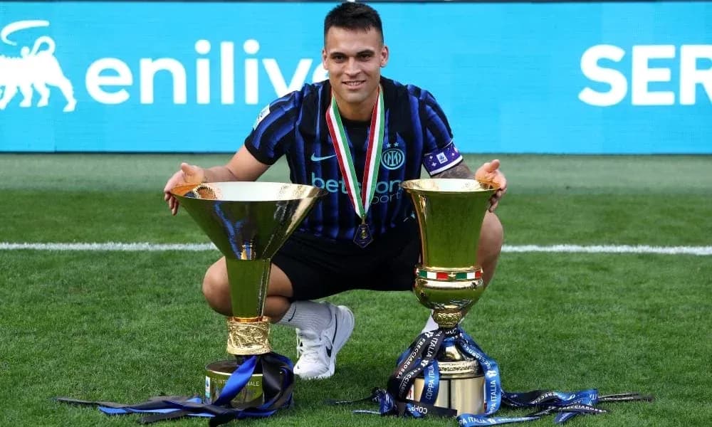 Player celebrating with two trophies on field
