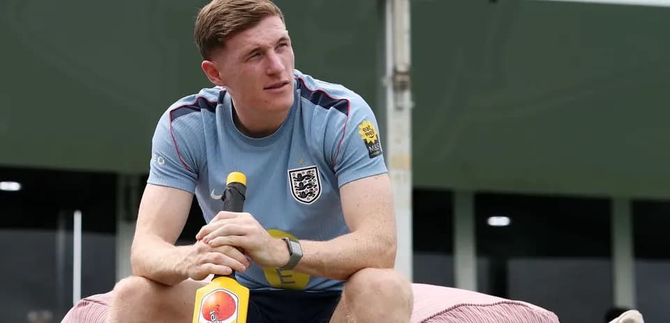 Player sitting with a cricket bat at training camp