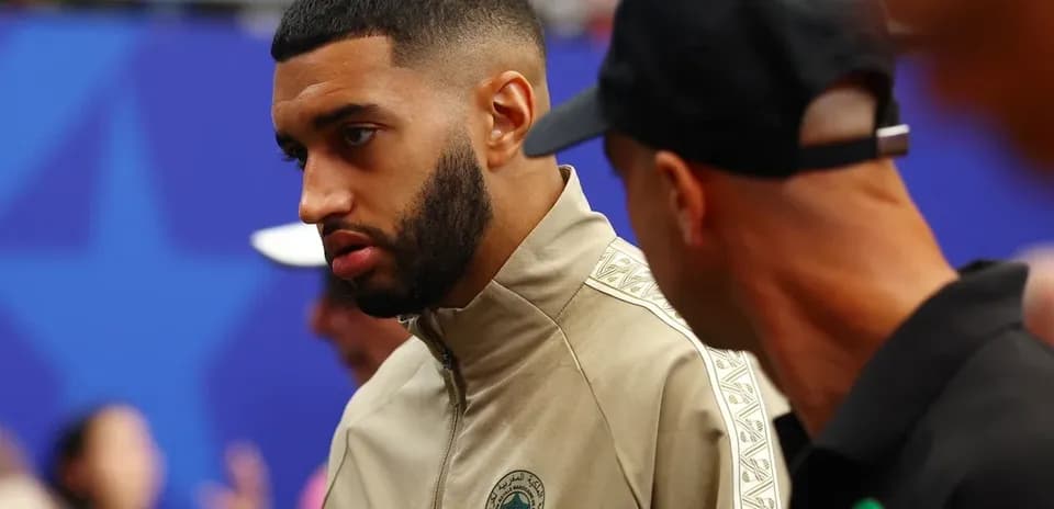 Player in Morocco training gear talking with teammate