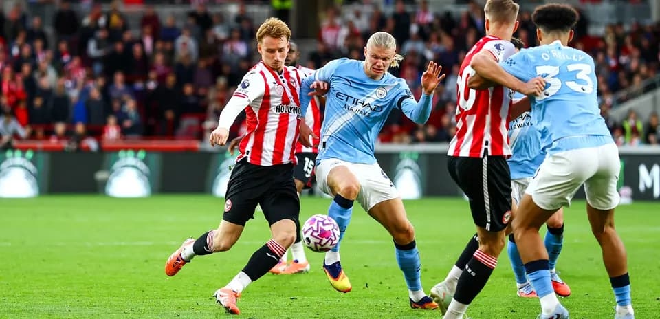 Manchester City player dribbling against Brentford defenders