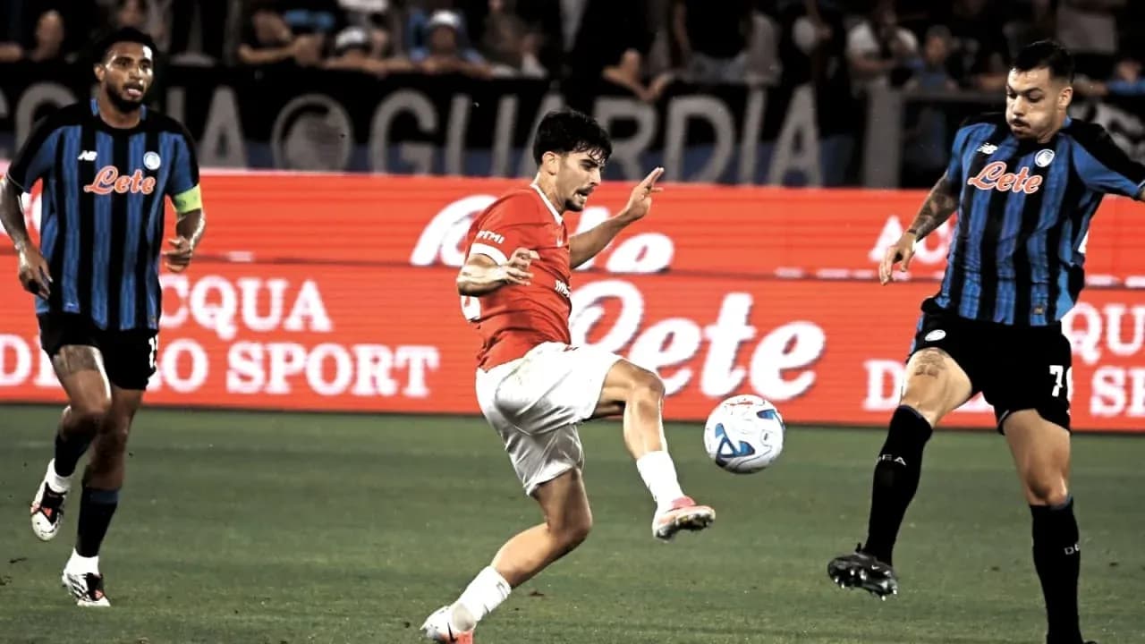 Player kicking ball during match with opposing players nearby
