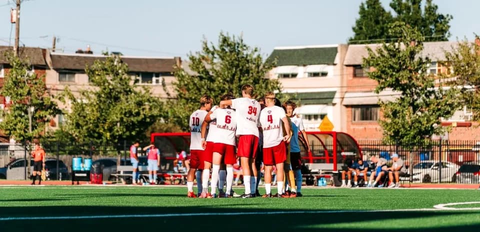 Team huddling together on the soccer field