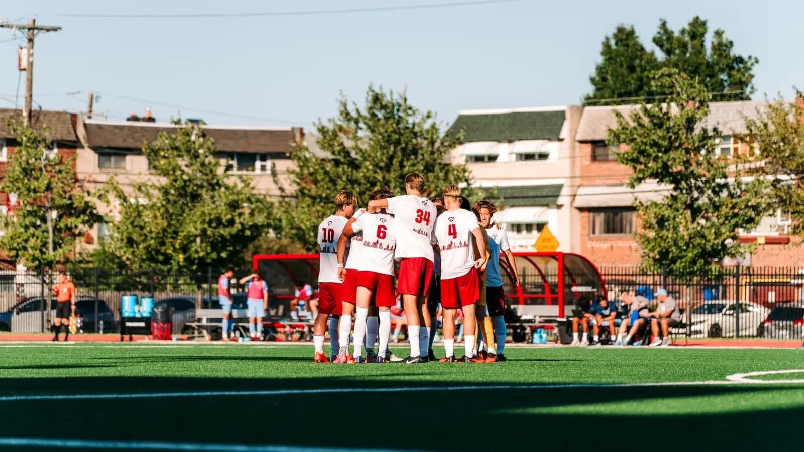 Team huddling together on the soccer field
