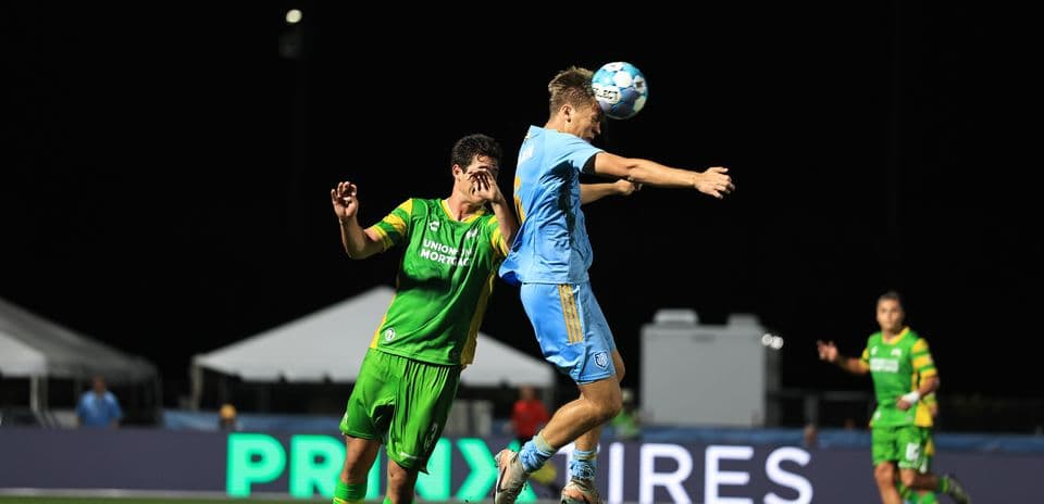 Players contesting a header during match