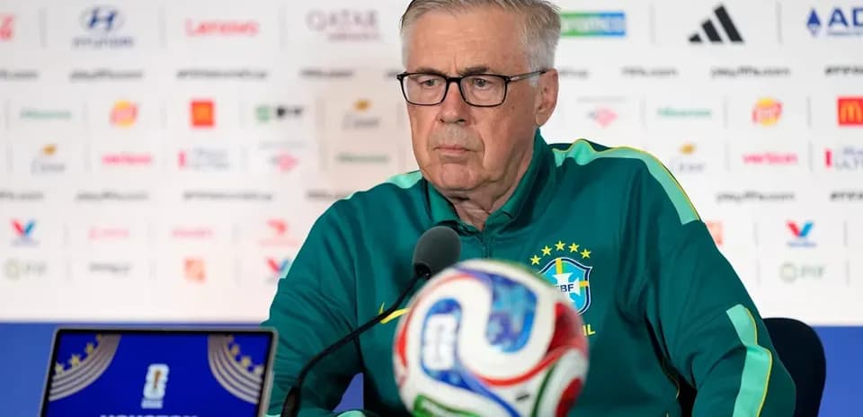 Coach at press conference with soccer ball in front