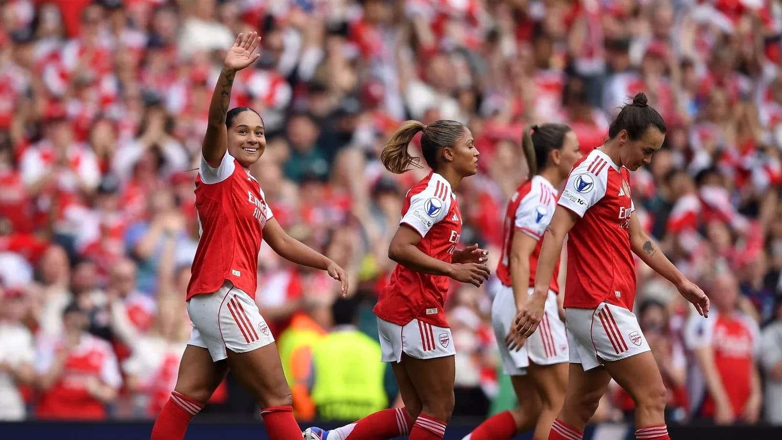 Arsenal players celebrating a goal with fans in background