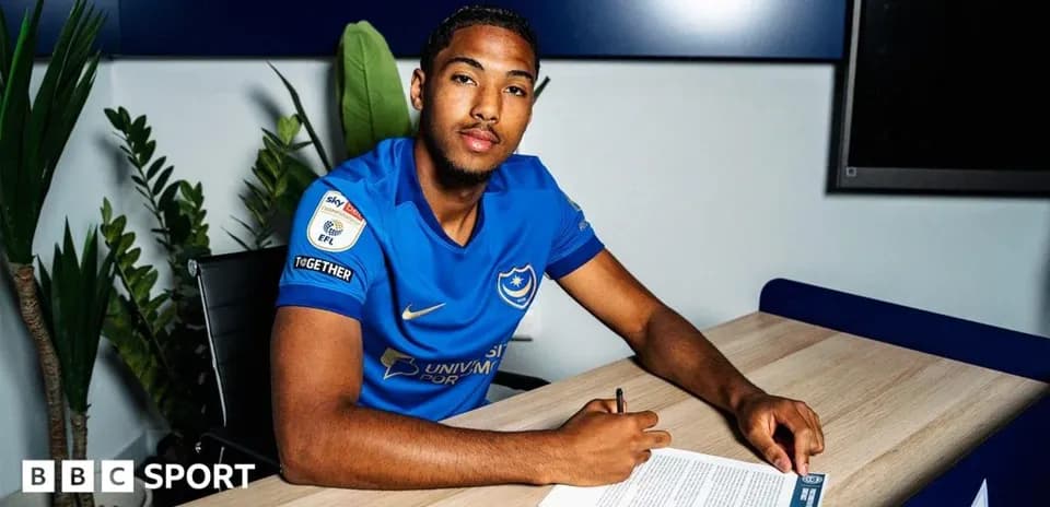 Player signing contract at desk in club office