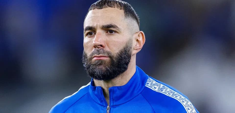 Football player in blue training jacket looking focused