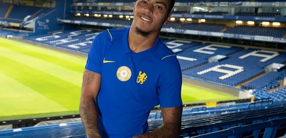 Player posing in Chelsea's stadium stands