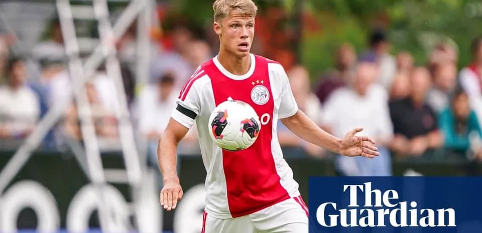 Player in Ajax kit controlling ball during match