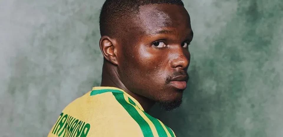 Player posing in national team jersey with green background