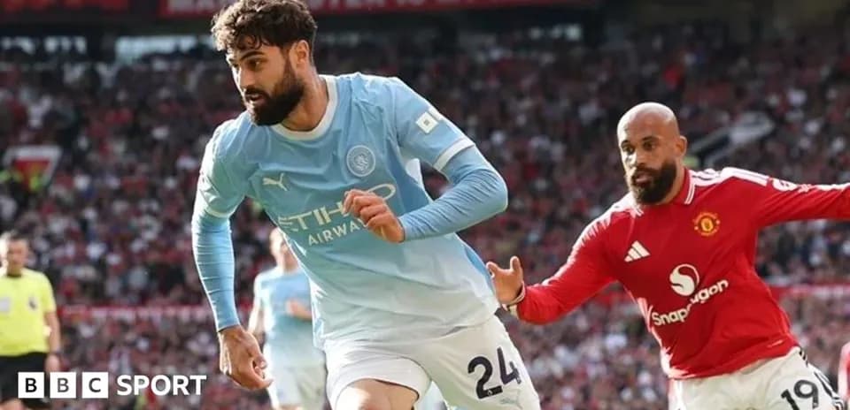 Manchester City player running past Manchester United opponent