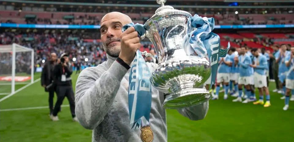 Coach holding FA Cup trophy at Wembley Stadium