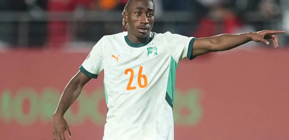 Player in Ivory Coast jersey directing teammates on field