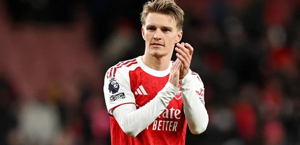 Player applauding fans after match in red jersey