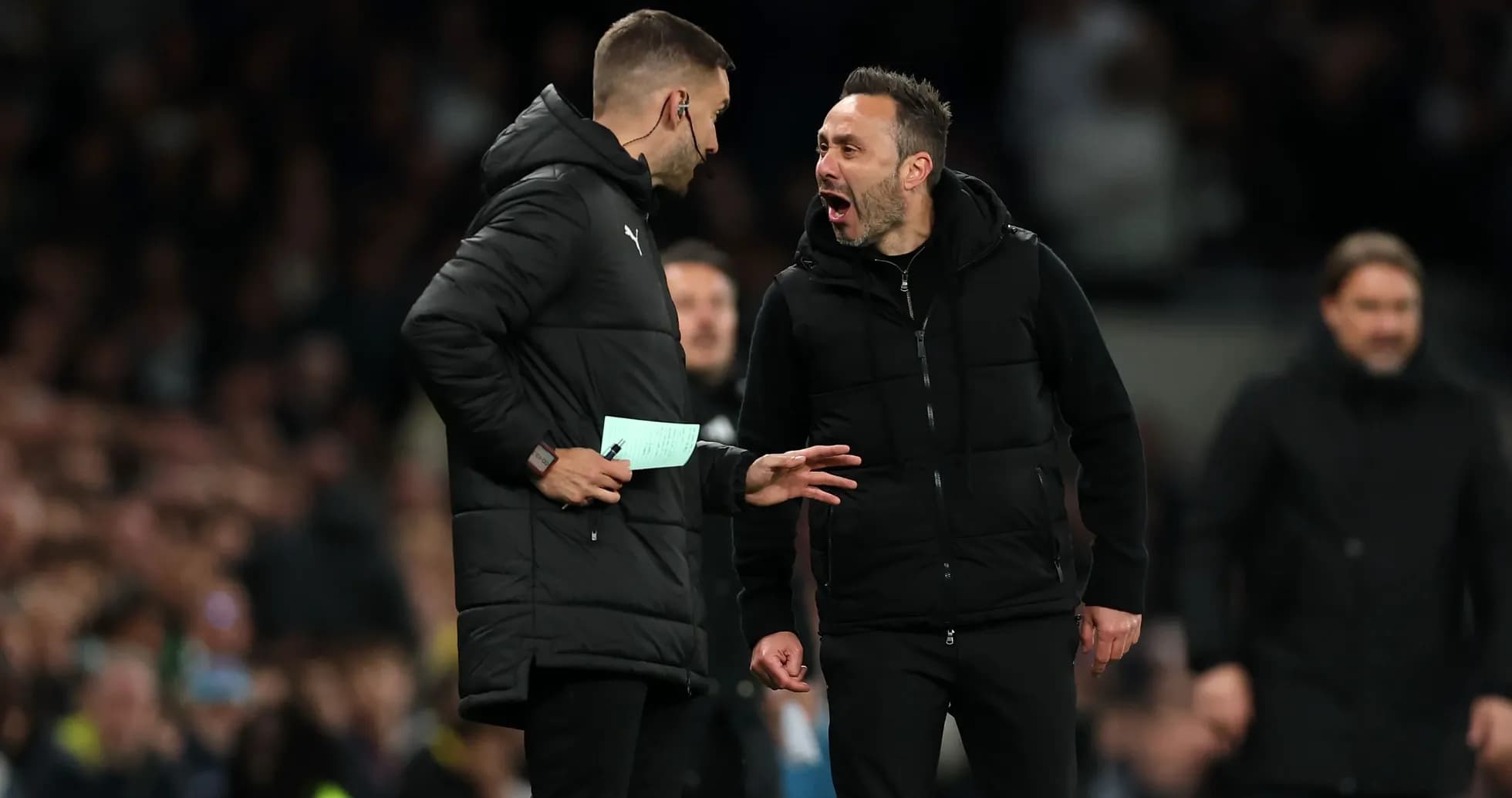 Two coaches discussing strategy during a match