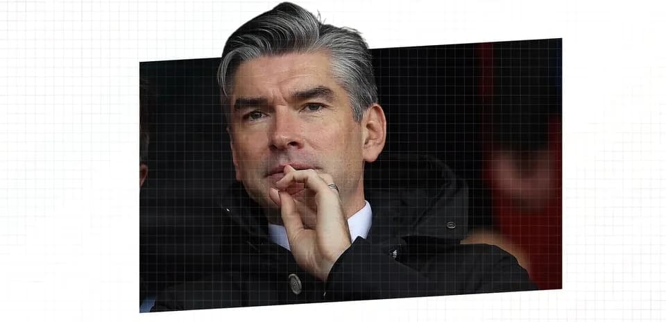 Man in a coat watching a sports event