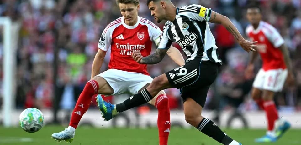 Newcastle player kicking ball against Arsenal opponent