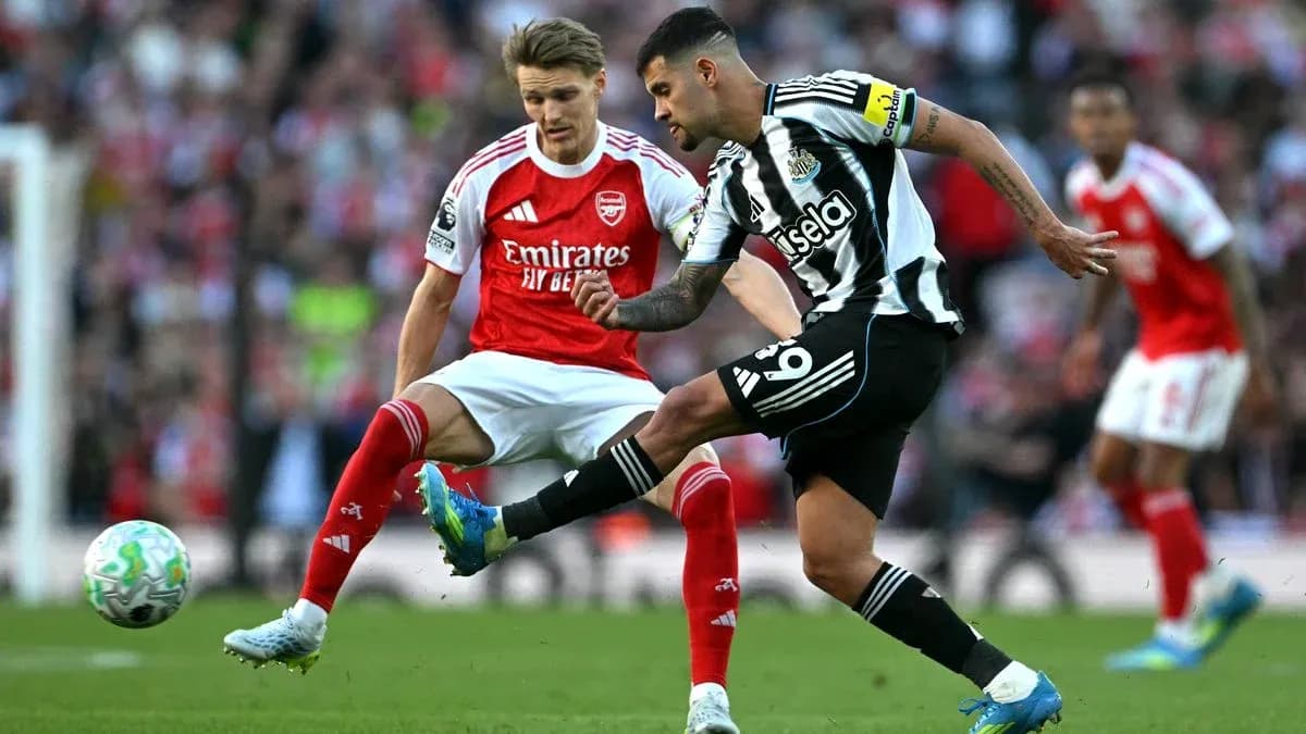 Newcastle player kicking ball against Arsenal opponent