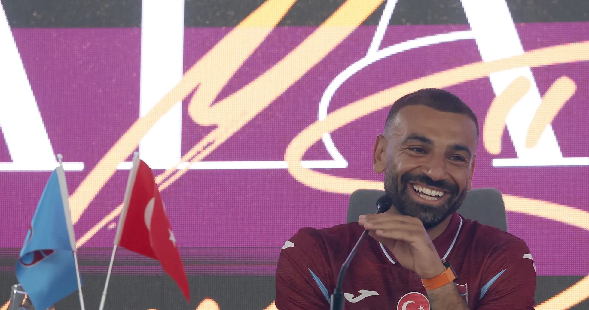 Player at press conference with Turkish flags