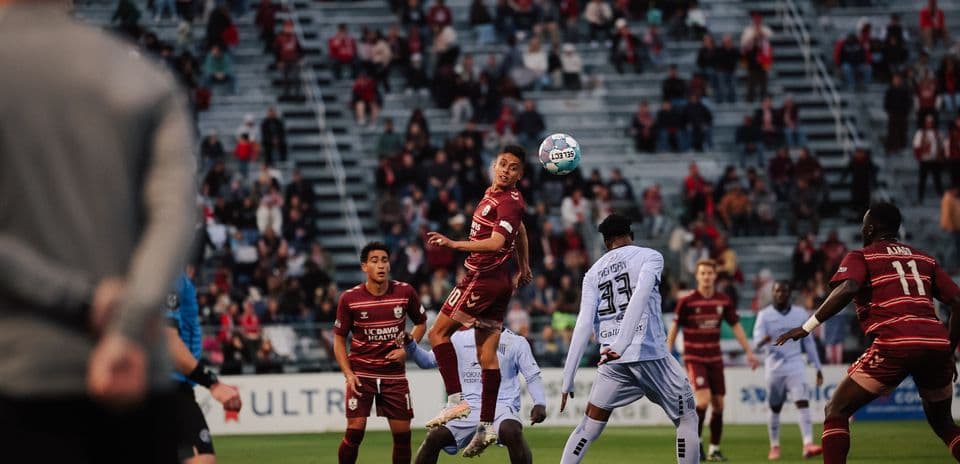 Spokane Velocity player heading the ball during match