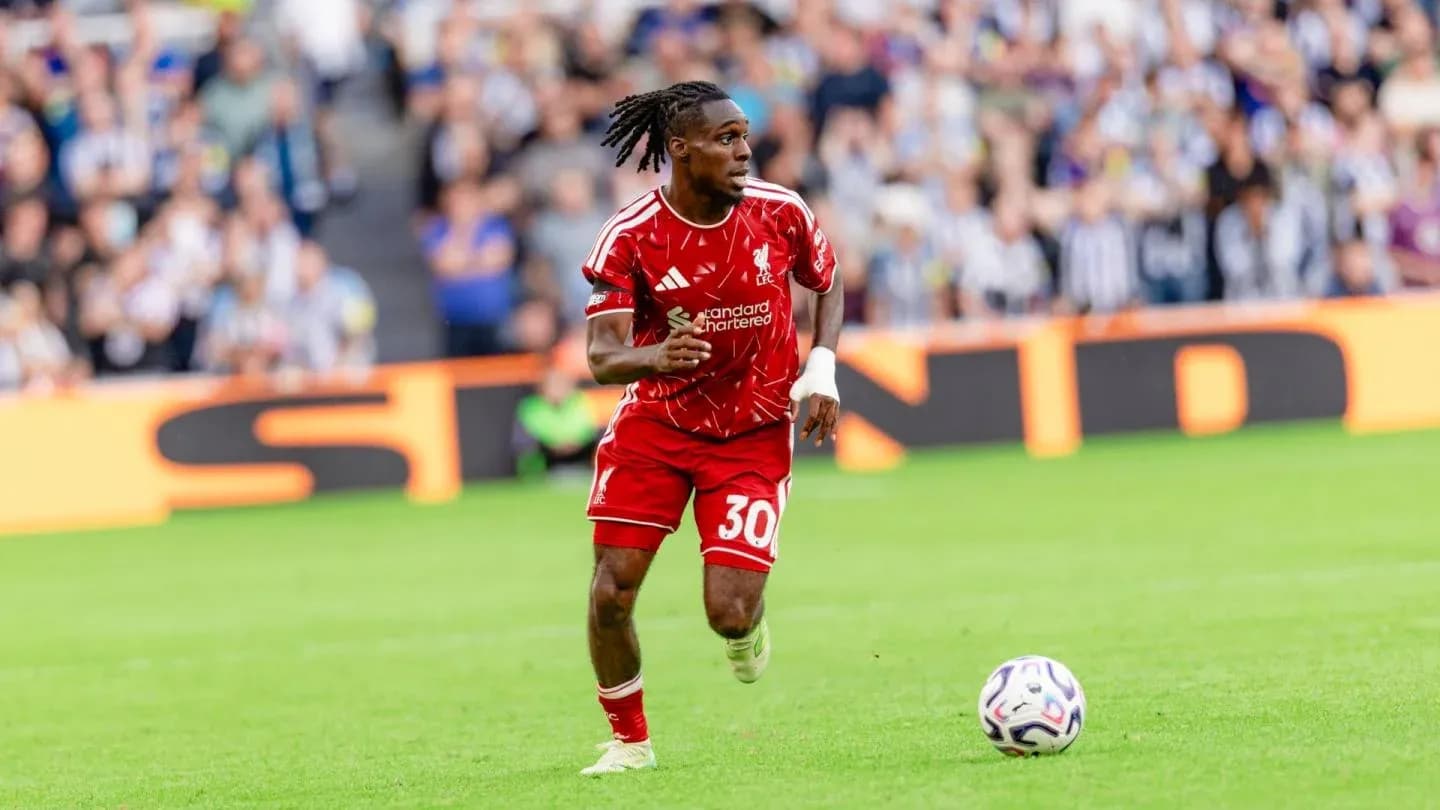 Player in red kit running with ball during match
