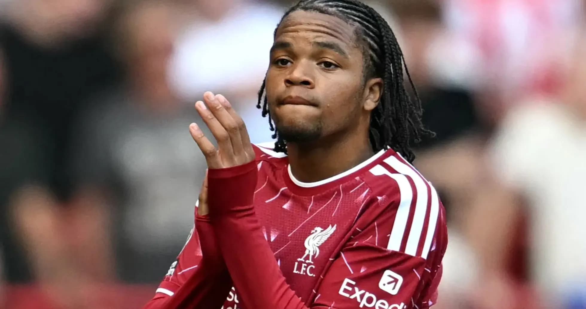 Player applauding fans while wearing Liverpool jersey