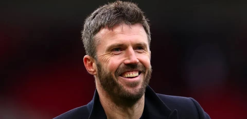 Man smiling on the sidelines of a stadium
