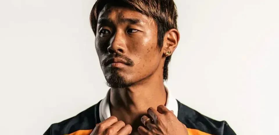 Athlete posing in sports jersey with hands on collar