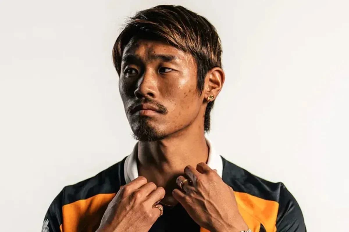 Athlete posing in sports jersey with hands on collar