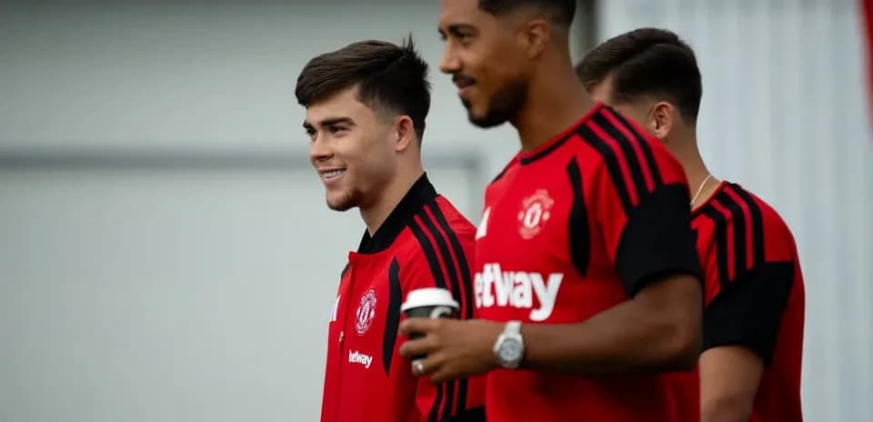 Two Manchester United players in training gear smiling