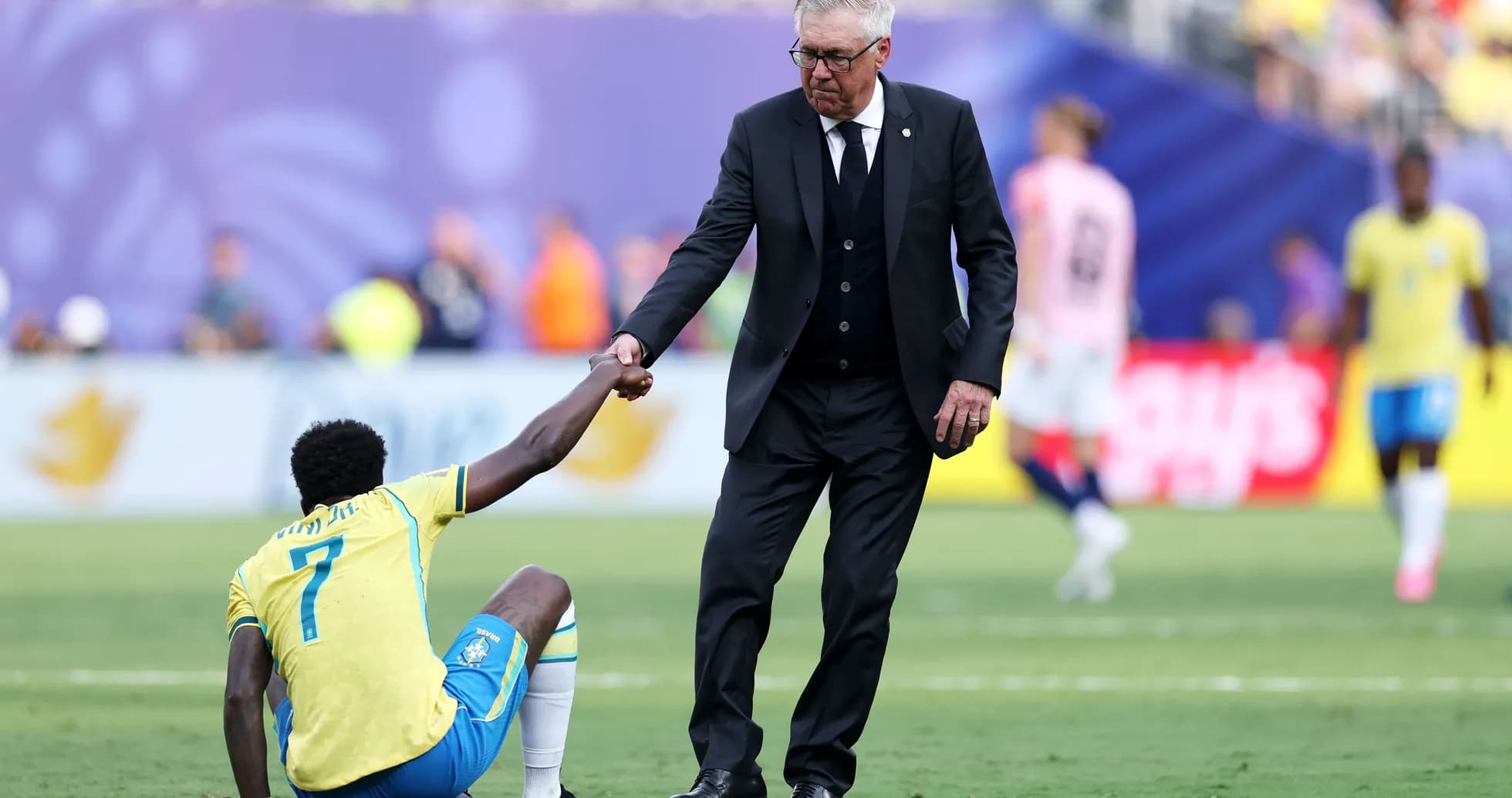 Coach helping player up from the ground during match