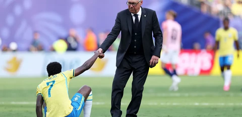 Coach helping player up from the ground during match