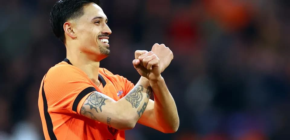 Player celebrating with clenched fists in orange jersey