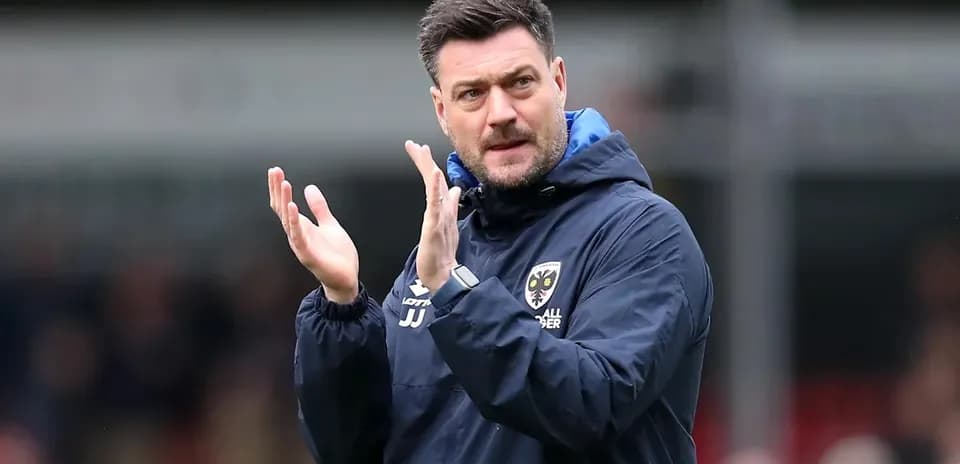 Coach clapping during a match on the sidelines
