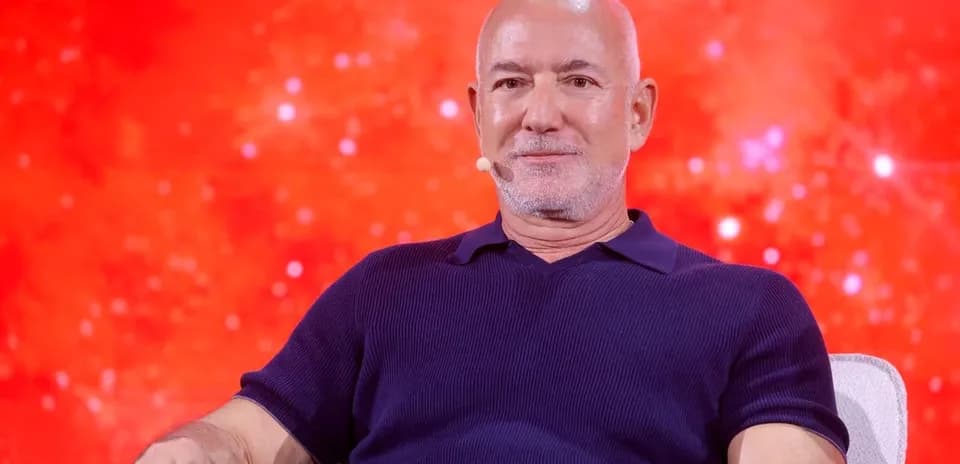 Person speaking on stage with red background