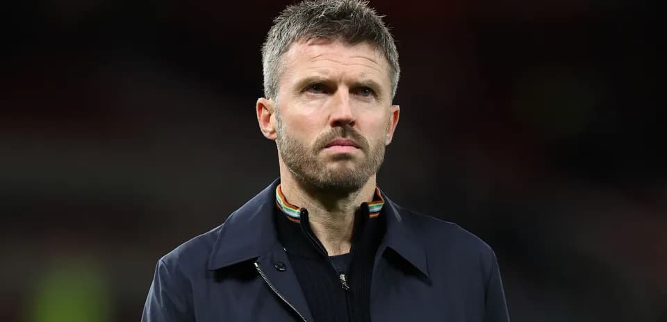 Man in dark jacket looking serious on field