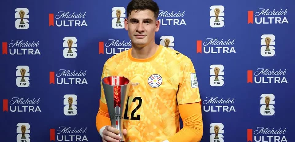 Goalkeeper holding trophy at post-match ceremony