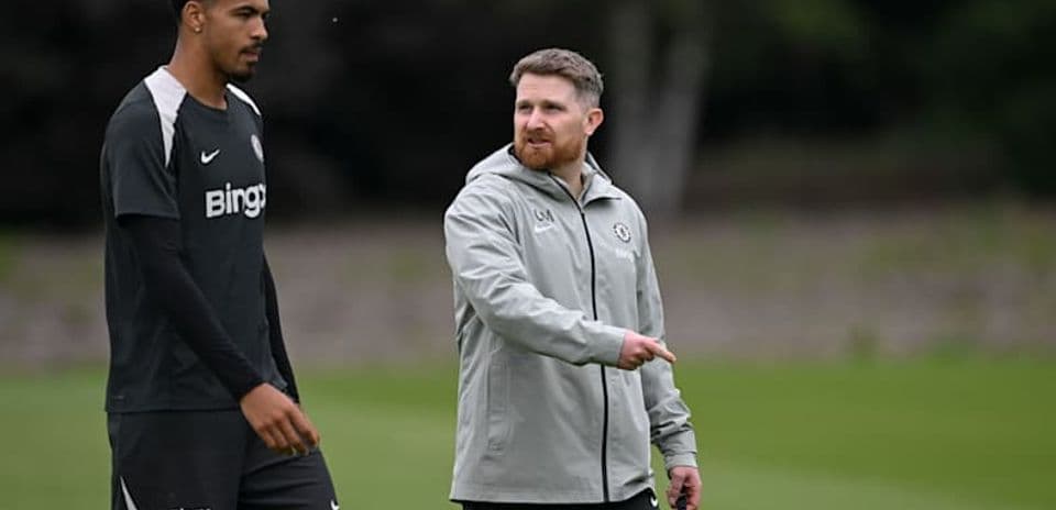 Player and coach walking on training ground