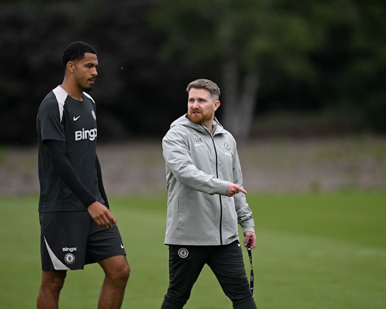 Player and coach walking on training ground
