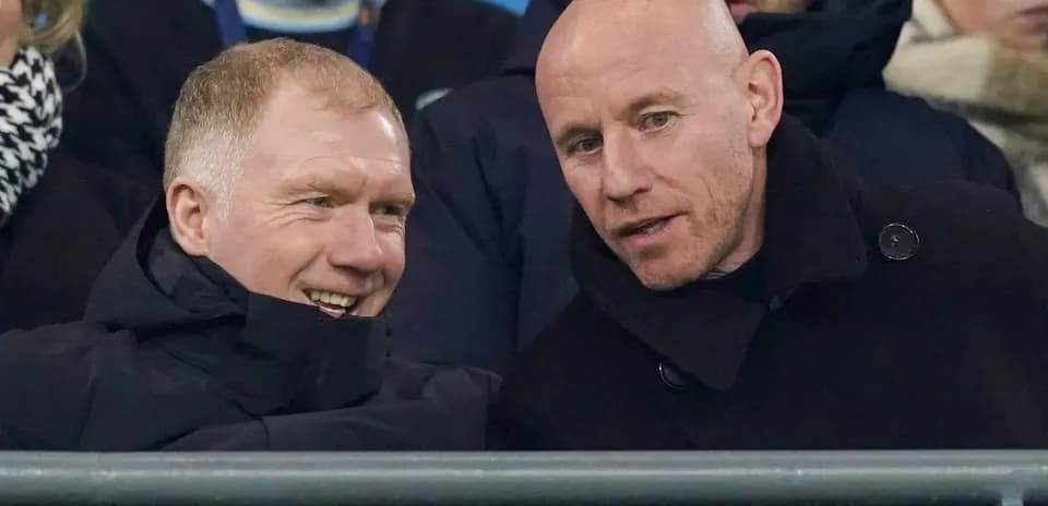 Two men conversing in the stands at a match