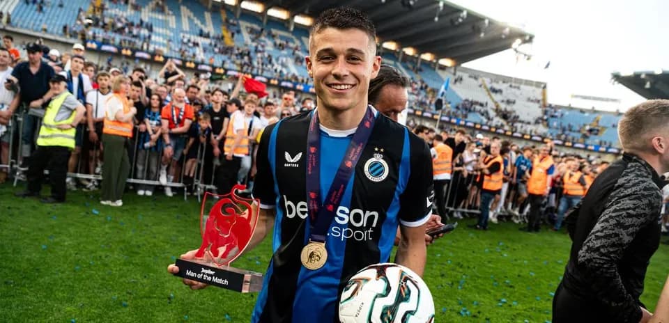 Player holding trophy and ball after match celebration