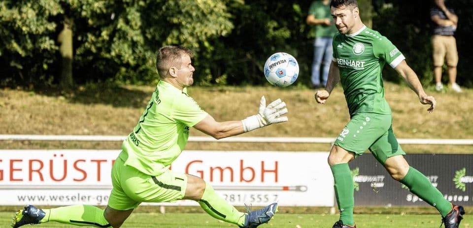 Goalkeeper attempting to catch a ball during match