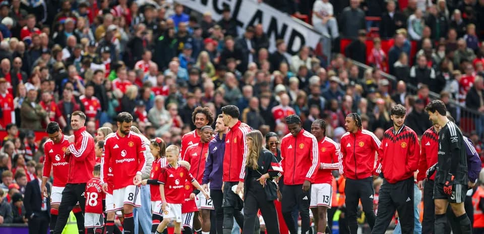 Manchester United players entering the pitch with fans