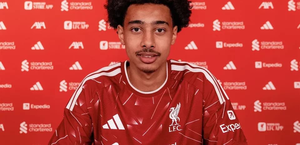 Player signing contract in Liverpool FC jersey