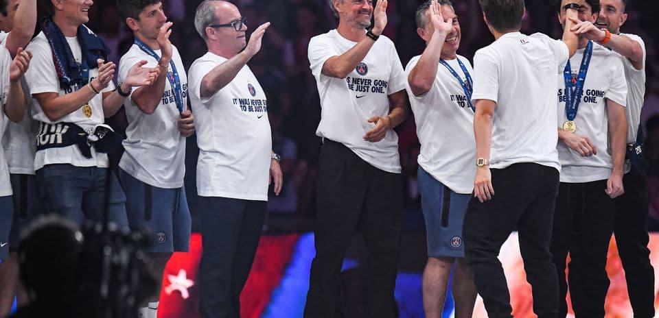 Team celebrating with T-shirts and medals on stage