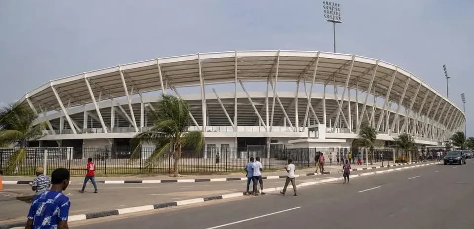 Exterior view of a stadium with pedestrians nearby