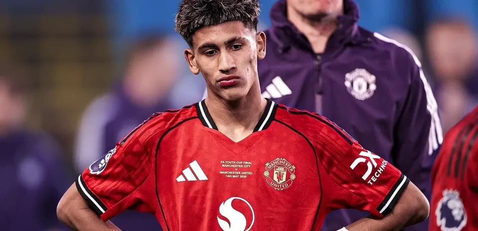 Young player wearing Manchester United jersey looking down